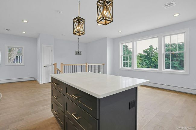 Kitchen featuring plenty of natural light, recessed lighting, light wood-style flooring, light countertops, and decorative light fixtures | Image 12