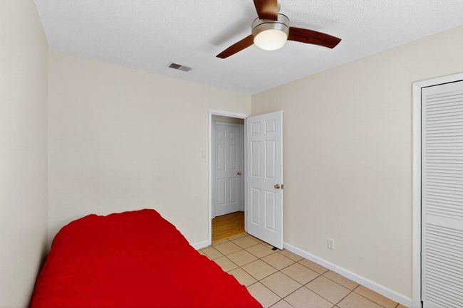 Unfurnished bedroom with light tile patterned flooring, a ceiling fan, a textured ceiling, and a closet | Image 14