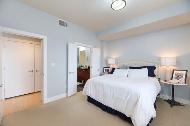 Bedroom featuring light carpet and ensuite bathroom | Image 16