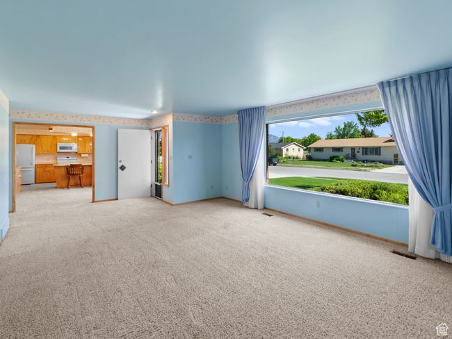 Unfurnished living room featuring carpet and custom drapery | Image 12