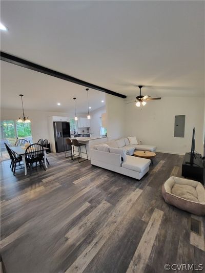 Living room with dark wood-type flooring and ceiling fan | Image 2