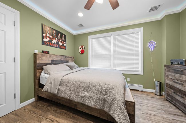 Living room featuring light wood-style floors, a baseboard heating unit, recessed lighting, a barn door, and baseboards | Image 29