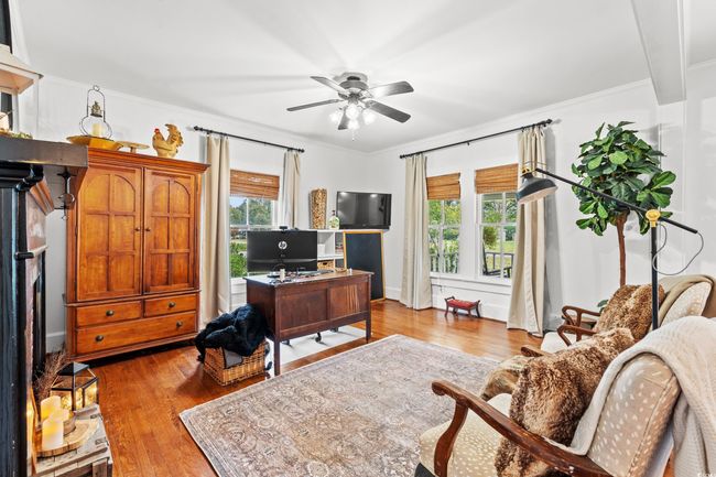 Office space featuring healthy amount of natural light, wood finished floors, crown molding, and ceiling fan | Image 14