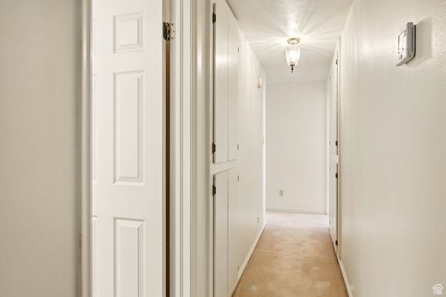 Corridor featuring light carpet and baseboards | Image 23