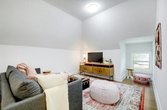 Second story living area with vaulted ceiling and wood finished floors | Image 25