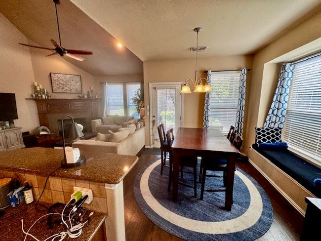 Dining area with a wealth of natural light, ceiling fan with notable chandelier, and dark wood finished floors | Image 19