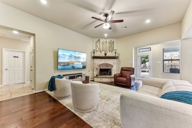 High ceilings, rich hardwood floors, and oversized windows make this living room feel both grand and inviting | Image 8