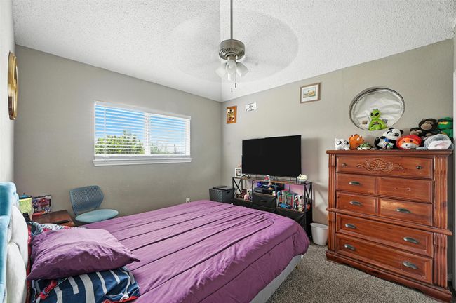 Carpeted bedroom with a textured ceiling and ceiling fan | Image 20