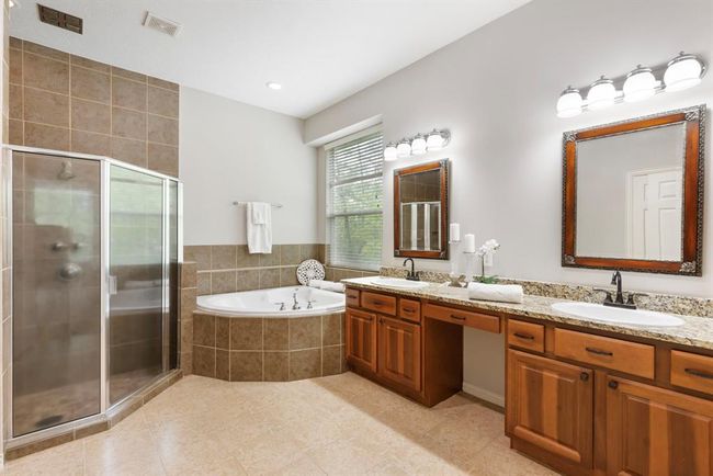 Primary bathroom with double vanities, tub and separate shower. | Image 21
