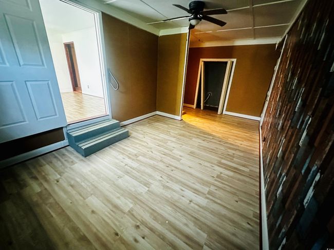 Unfurnished room featuring a ceiling fan, wood finished floors, and baseboards | Image 7
