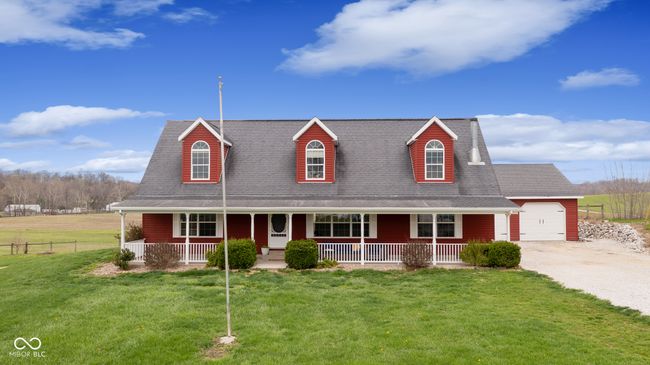 cape cod-style house with a porch, a shingled roof, a front yard, and gravel driveway | Image 4