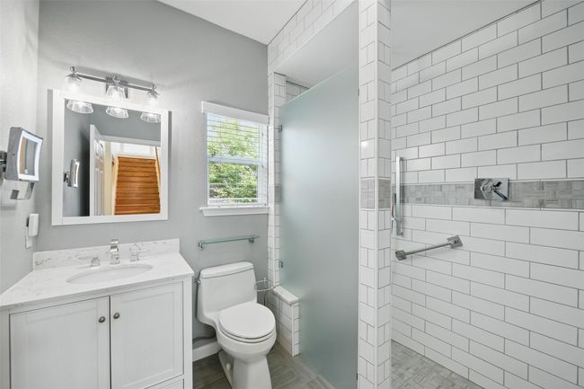 There is a full bathroom downstairs with a walk-in shower. | Image 9