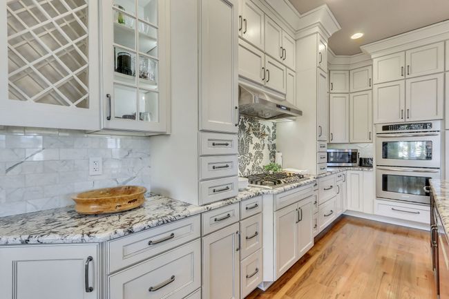 No detail has been left out in this beautiful space to create. Soft close drawers and cabinetry, double ovens, five burner gas range with pot filler, shimmering tile backsplash and storage galore. | Image 18