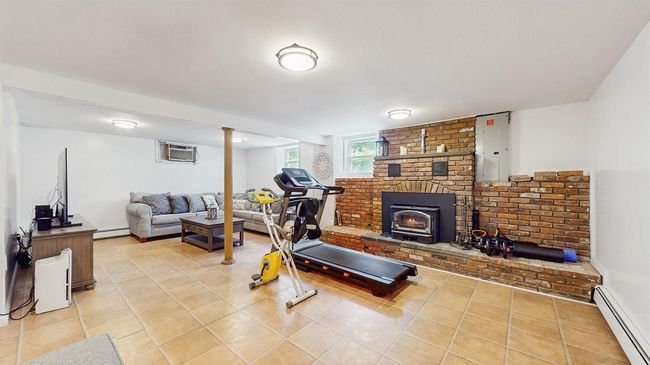 Awesome Family Room, perfect for large family get-togethers! It features a baseboa light tile ceramic floors, a wall mounted air conditioner and a cozy, wood burning brick Fireplace! | Image 28