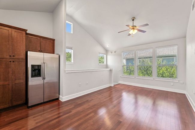 Kitchen with stainless steel fridge, ceiling fan, dark wood-style floors, and high vaulted ceiling | Image 11