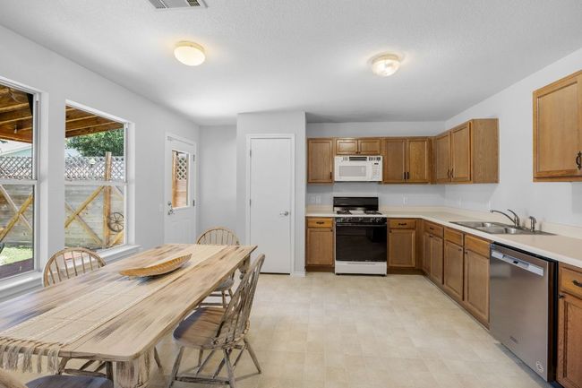 Kitchen features a dining area, plenty of cabinet space, and a pantry. | Image 8