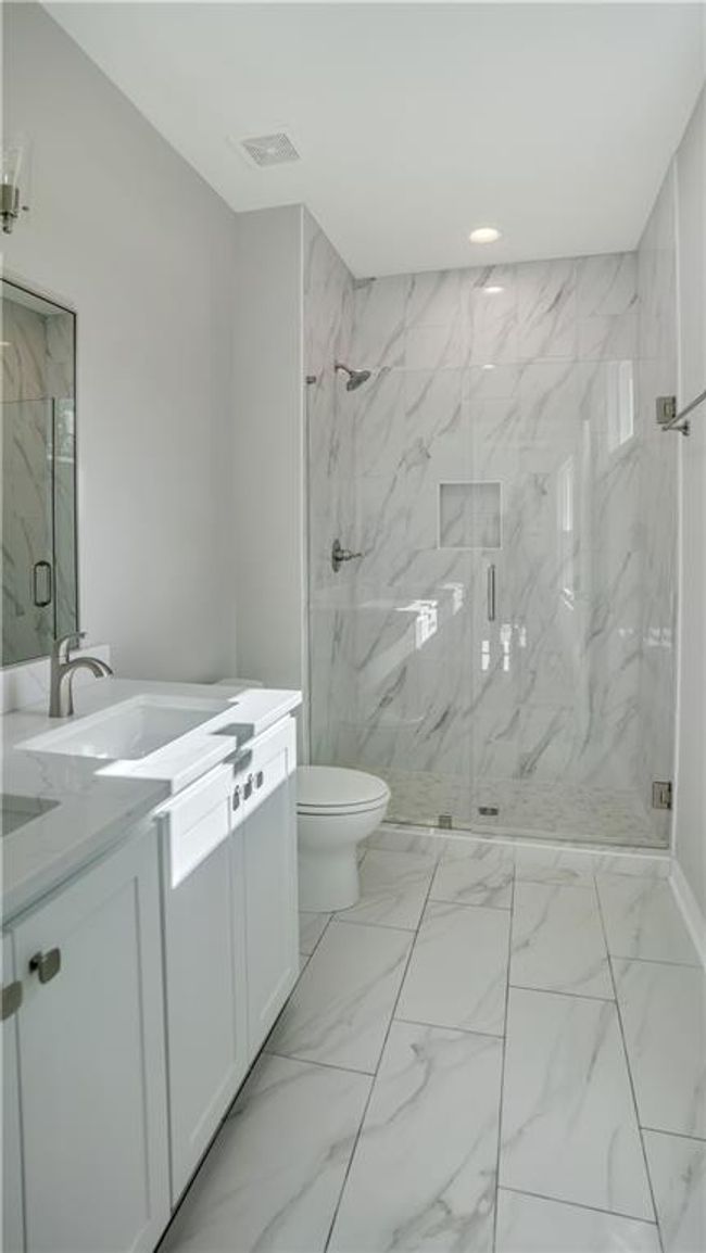 Full bath featuring vanity, marble finish flooring, a marble finish shower, toilet, and recessed lighting | Image 18