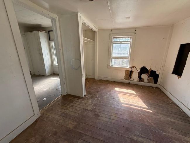 Unfurnished bedroom with wood-type flooring and a closet | Image 11