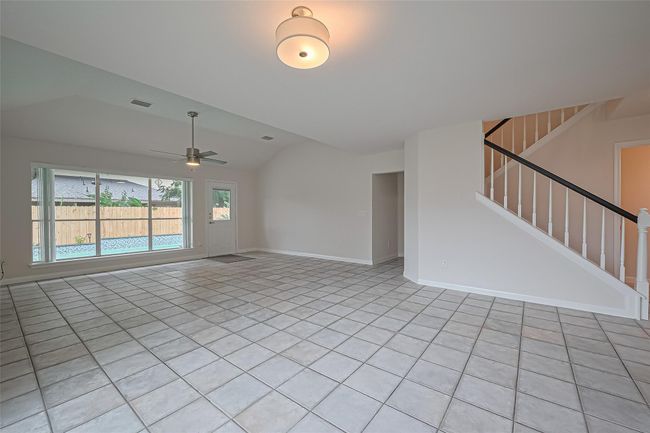 Open-concept dining and living area filled with natural light and offering beautiful views of the pool and backyard oasis. | Image 7