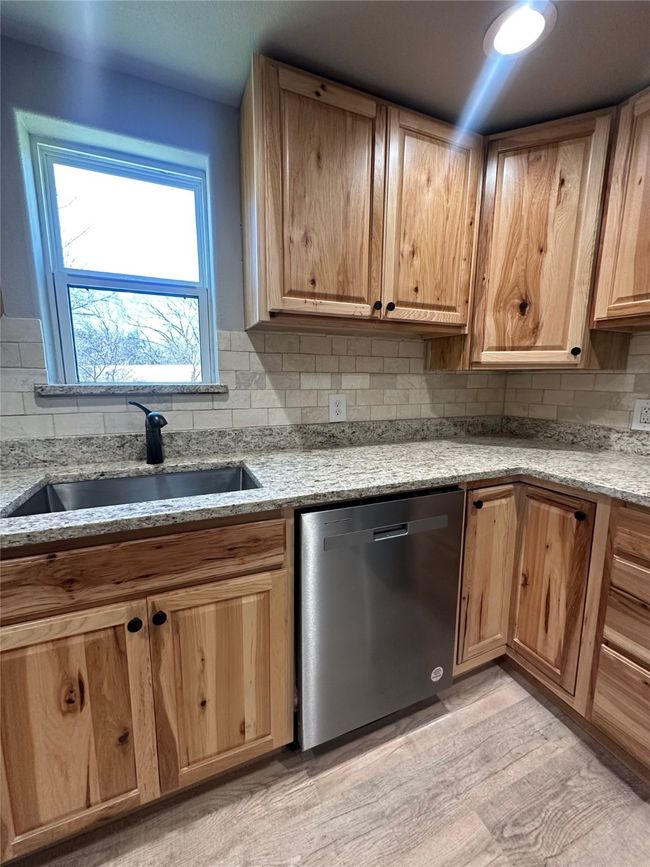 Kitchen featuring a sink, tasteful backsplash, light stone countertops, and stainless steel dishwasher | Image 16