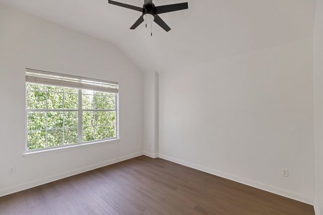 Empty room featuring a ceiling fan, dark wood finished floors, and lofted ceiling | Image 19