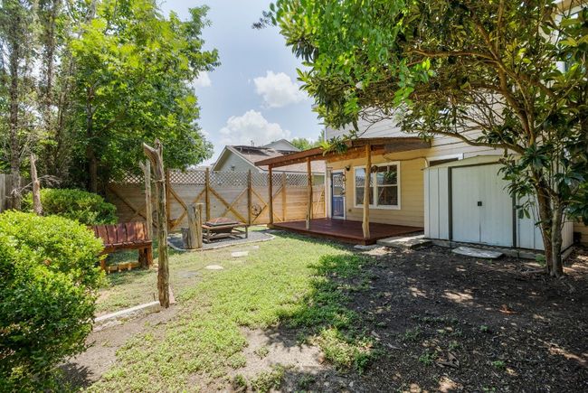 View of yard with a wooden deck, storage shed, and fire pit. | Image 27