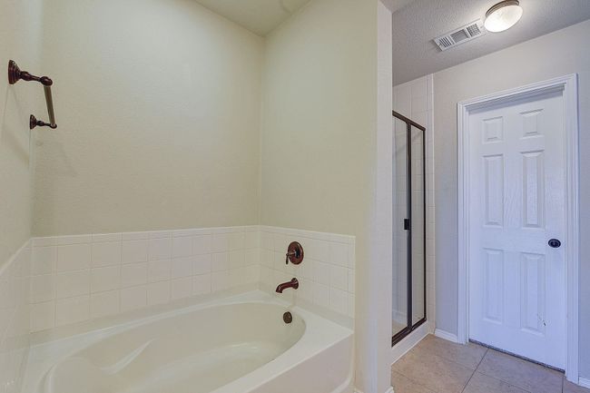 Full bath featuring a bath, a stall shower, and tile patterned floors | Image 13