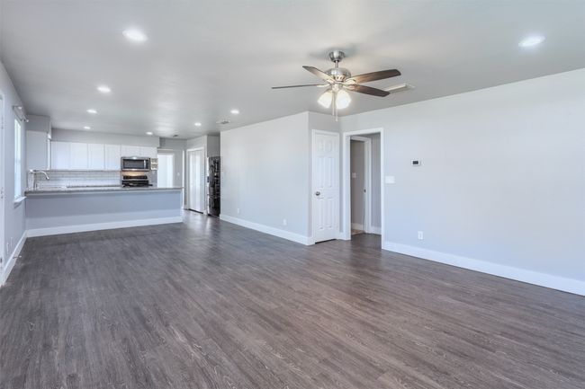 Unfurnished living room featuring recessed lighting, a sink, dark wood-style flooring, baseboards, and ceiling fan | Image 6