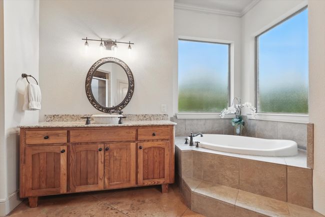 Full bath featuring a garden tub, vanity, healthy amount of natural light, and ornamental molding | Image 19