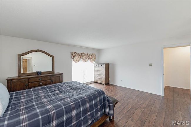 Bedroom with dark wood-style flooring and baseboards | Image 33