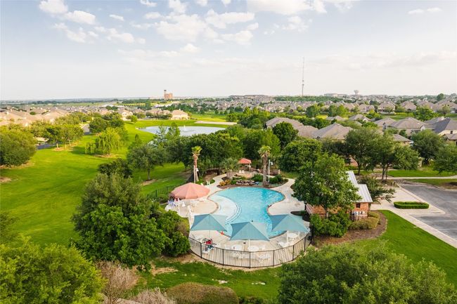Aerial perspective of suburban area featuring a pool and a nearby body of water | Image 27
