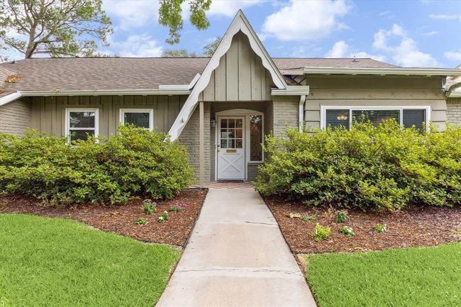 Discover this charming cottage-style home featuring a welcoming glass and wood door. | Image 18