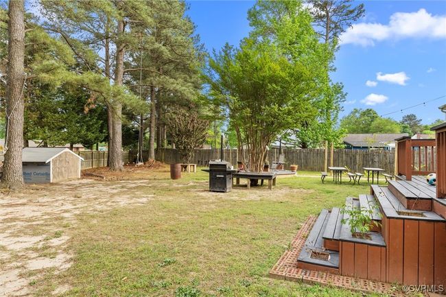 View of yard featuring an outdoor structure, a storage shed, a deck, and a fenced backyard | Image 35