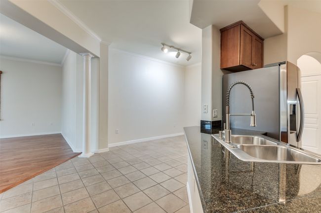 Sip your morning coffee or evening aperitifs at the eat-at bar, while the seamless open layout offers sweeping sightlines from the kitchen through the dining and living areas—framed by breathtaking panoramic views of Las Colinas, Lake Carolyn, and the Dallas skyline. | Image 22
