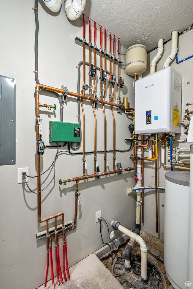 Utilities featuring tankless water heater and electric panel | Image 88