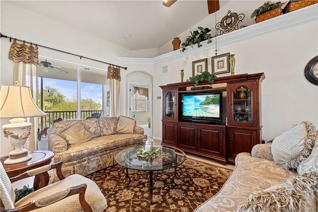 Living room with ceiling fan, visible vents, and high vaulted ceiling | Image 13