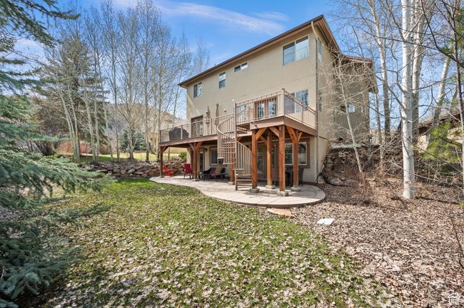 Rear view of house featuring stairs, a patio, stucco siding, and a deck | Image 33