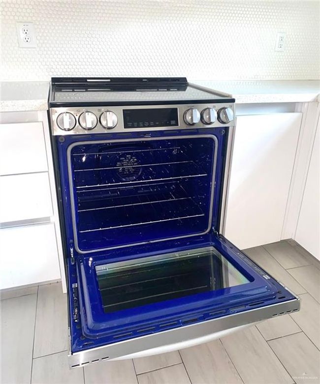 Detailed view of tasteful backsplash and stainless steel range with electric cooktop | Image 4