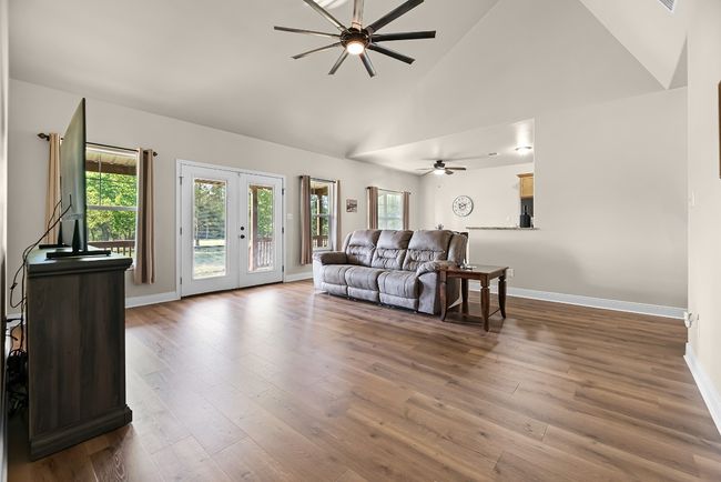 Living room featuring wood finished floors, high vaulted ceiling, a ceiling fan, and a wealth of natural light | Image 26