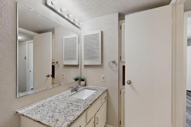 Bathroom featuring a textured ceiling, vanity, and a textured wall | Image 26