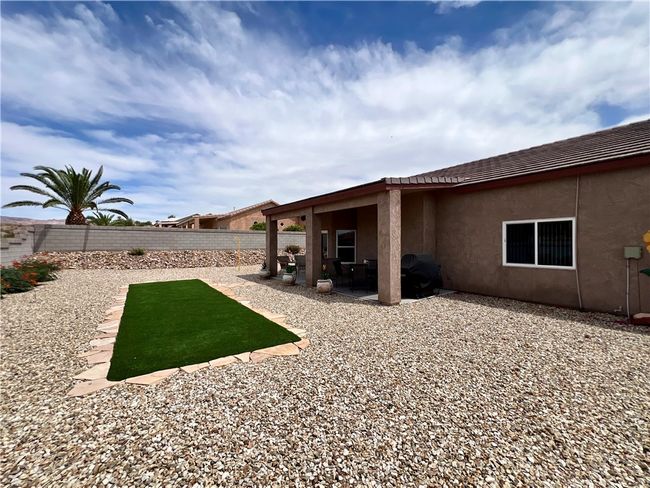 Fenced backyard with a patio area | Image 45