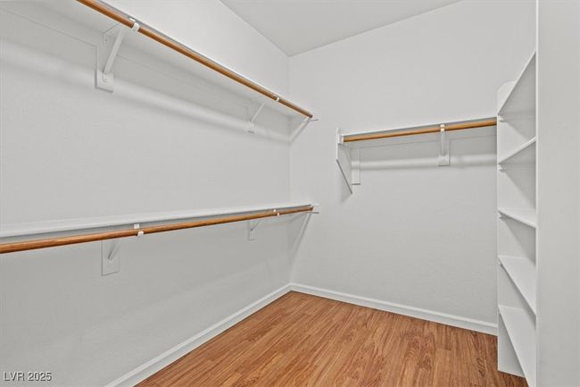 The sequestered primary suite is a true retreat, offering a large walk-in closet and a spa-inspired en suite bath with dual vanities, a soaking tub, and a separate walk-in shower. | Image 21