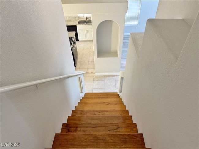 Staircase with tile patterned flooring and a textured wall | Image 42