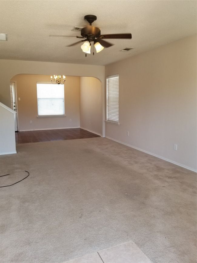 Spare room with arched walkways, a chandelier, carpet flooring, and a ceiling fan | Image 13
