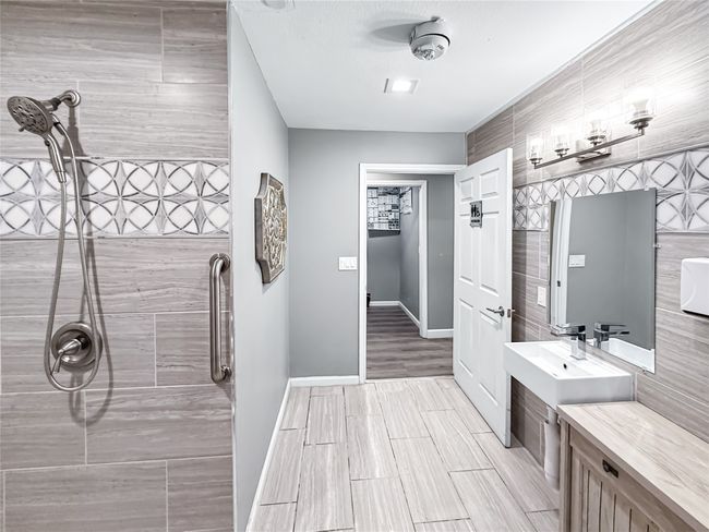 Bathroom with a tile shower, wood tiled floors, and vanity | Image 23