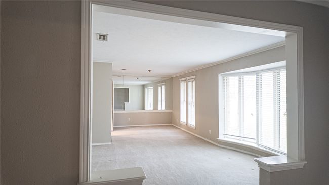 Spare room featuring ornamental molding, visible vents, baseboards, and carpet | Image 13
