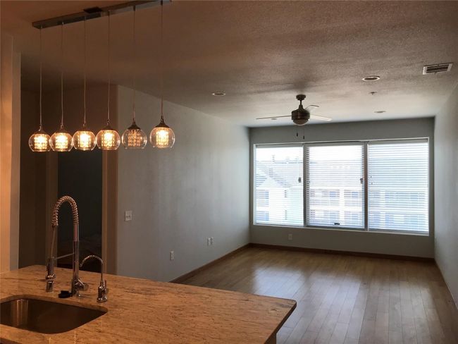 Kitchen with a sink, ceiling fan, light stone countertops, hardwood / wood-style floors, and pendant lighting | Image 10