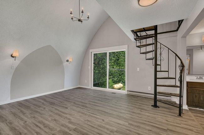 Large upper level primary retreat featuring an ensuite and spiral staircase to the loft. | Image 14