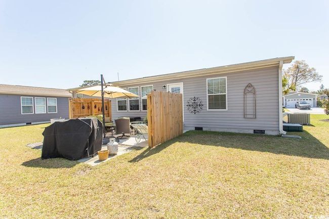 Rear view of house with cooling unit, crawl space, and a yard | Image 37