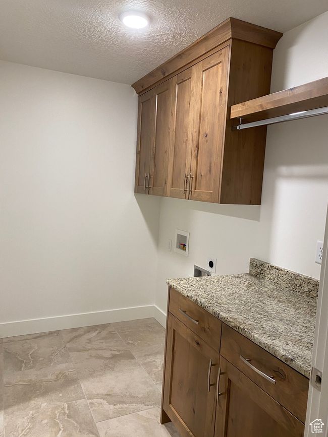 Laundry room with electric dryer hookup, cabinet space, hookup for a washing machine, and baseboards | Image 12